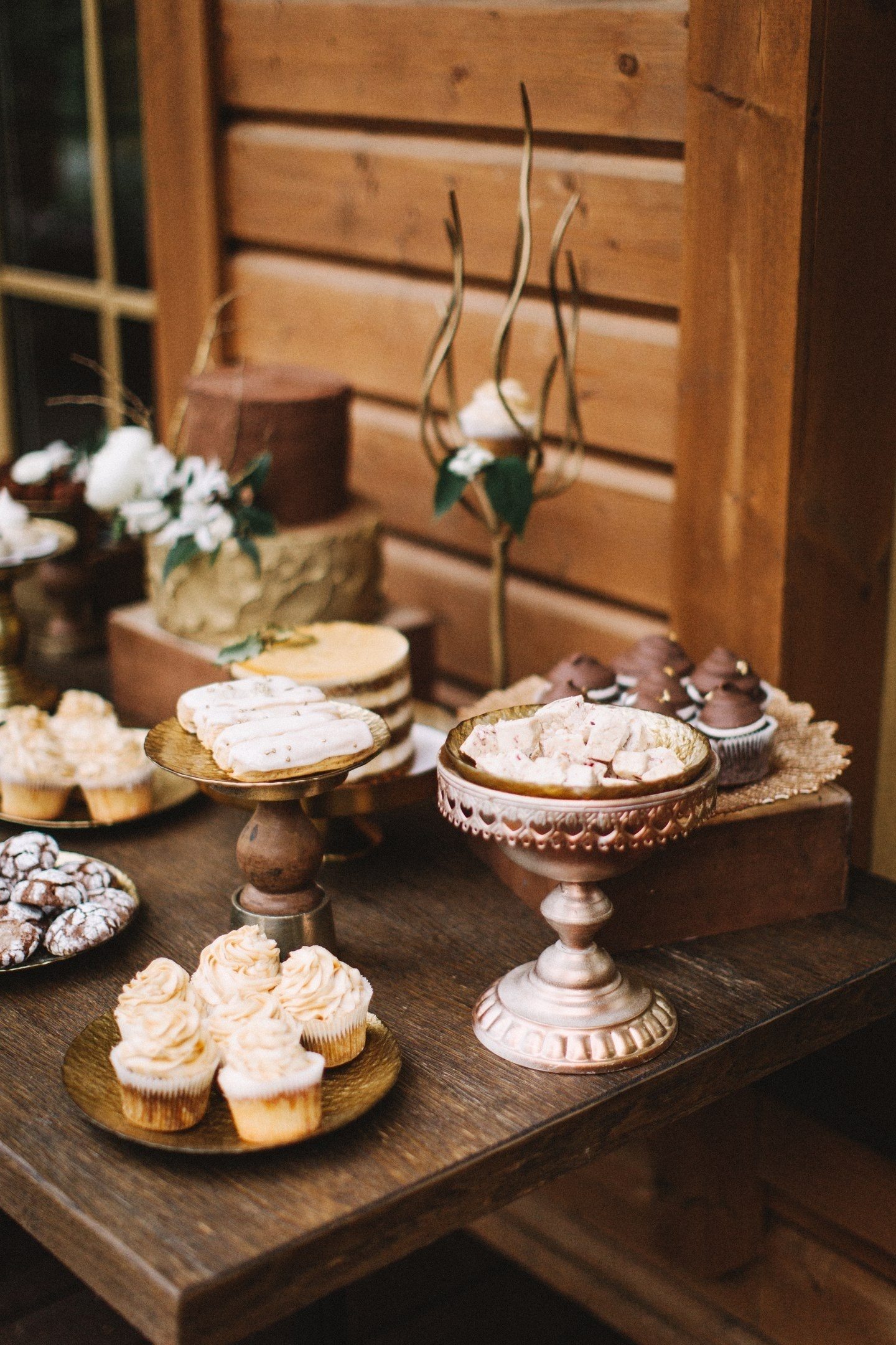 Złamane batoniki czekoladowe, trufle, zwiewne desery mokka, ozdobione ziarnami kawy i ażurowymi ciasteczkami z lukrem w stylu ślubnym świetnie prezentują się w towarzystwie starych pudełek i ozdobnych stojaków