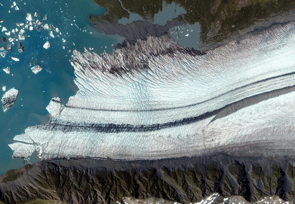 На фотографії зображений льодовик, розташований на півострові Кенан, уздовж затоки Аляска, що має довжину в 240 кілометрів