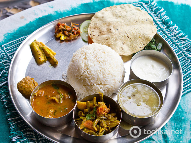 У центрі підношення завжди лежить жменю рису, чапати або роти (різновид хлібних коржів), а в мисочках - овочева юшка, йогурт, дхал, саджі, карі з овочів і інші страви індійської кухні
